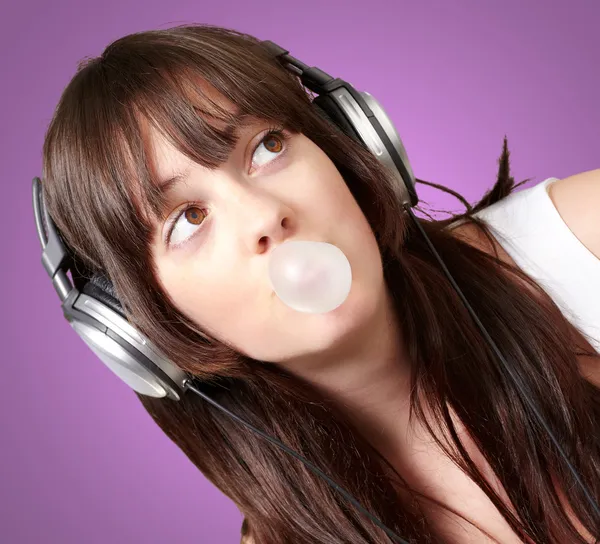 Портрет молодой женщины, слушающей музыку с жевательной резинкой — стоковое фото