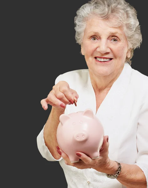 Portret van een volwassen vrouw met een piggy bank — Stockfoto