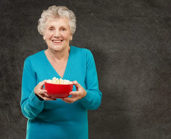 Senior woman holding popcorn — Stock Photo, Image