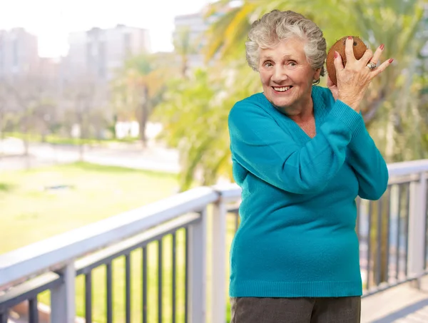 Senior femme heureuse tenant la noix de coco — Photo