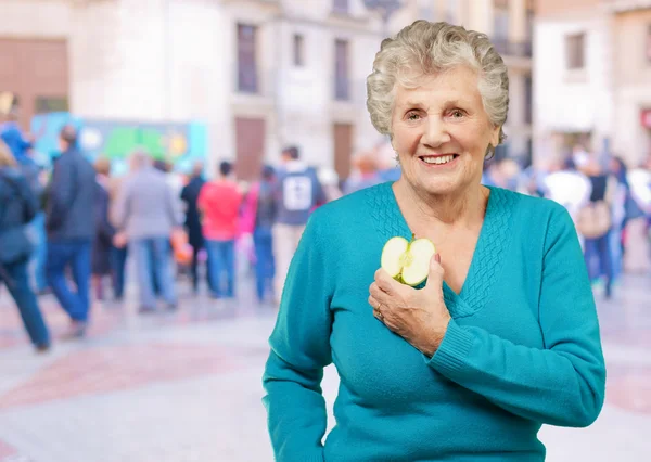 Porträt einer glücklichen reifen Frau beim Halten eines Apfels — Stockfoto