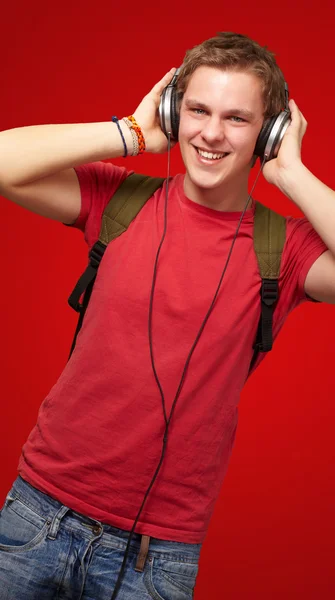 Retrato de un joven estudiante alegre escuchando música con auriculares —  Fotos de Stock