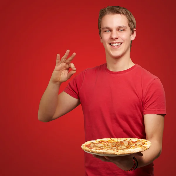 피자를 들고와 좋은 제스처 하 고 젊은 남자의 초상화 — 스톡 사진