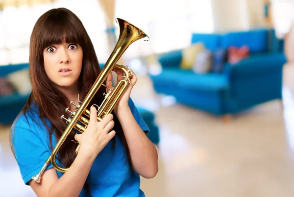 Mulher confusa segurando trompete — Fotografia de Stock