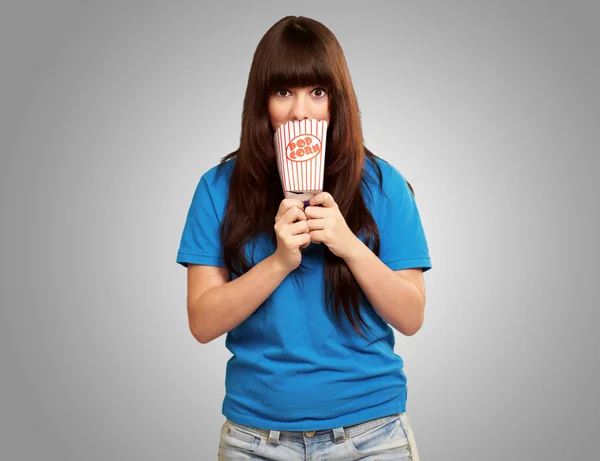 Girl holding empty popcorn packet — Stock Photo, Image