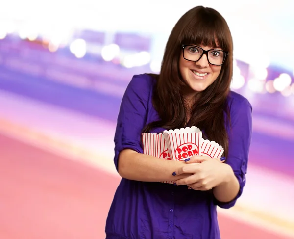 Porträt einer jungen Frau mit Popcorn-Behälter — Stockfoto