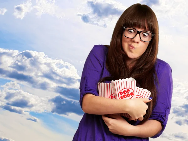 Porträt einer jungen Frau mit Popcorn-Behälter — Stockfoto