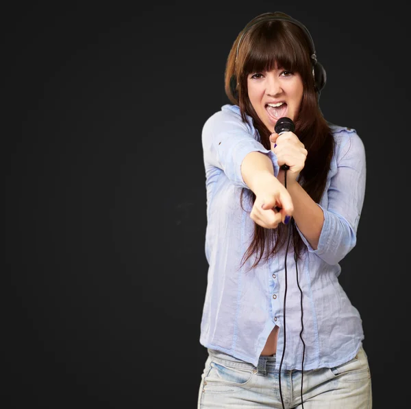 Menina com fone de ouvido cantando em Mike — Fotografia de Stock