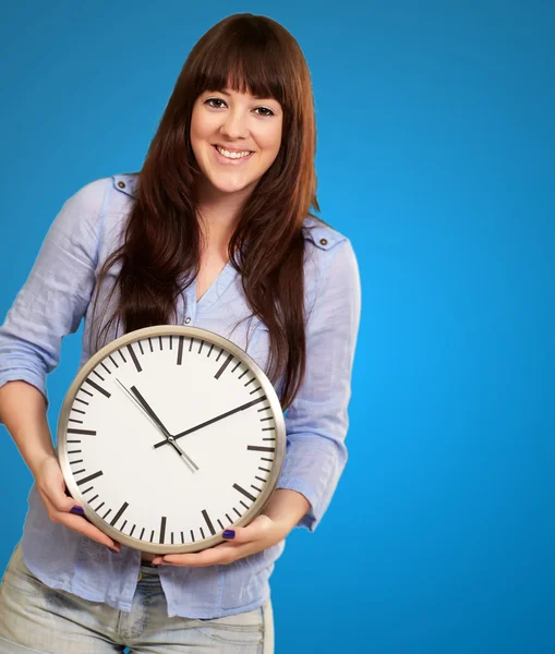 Una joven sosteniendo un reloj — Foto de Stock