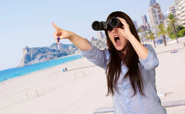 Retrato de una mujer joven mirando a través de prismáticos —  Fotos de Stock