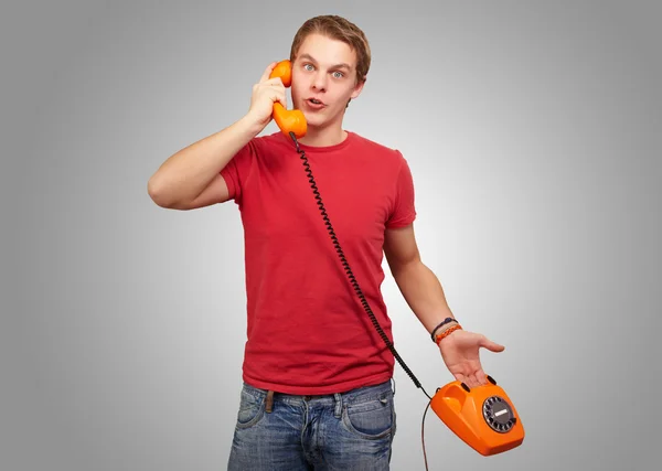 Portrait of a young man talking on vintage phone Stock Image
