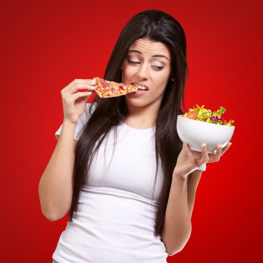 pizza yemek ve salata kırmızı üzerinde arayan genç bir kadın portresi