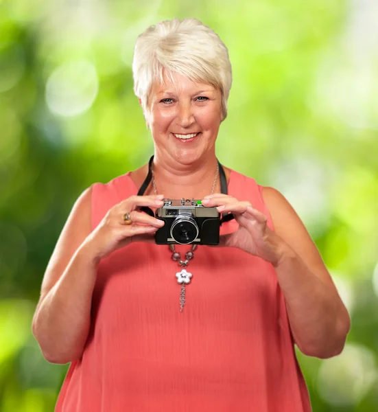 Donna anziana che tiene macchina fotografica — Foto Stock