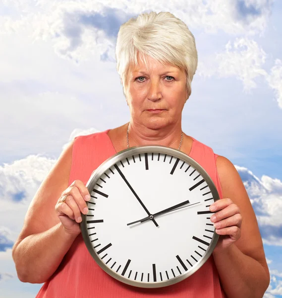 Starsza kobieta trzymająca zegar — Zdjęcie stockowe