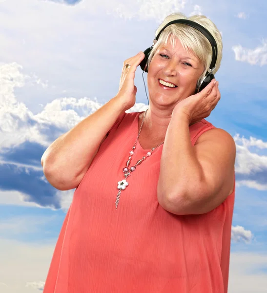 Retrato de una mujer mayor con auriculares — Foto de Stock