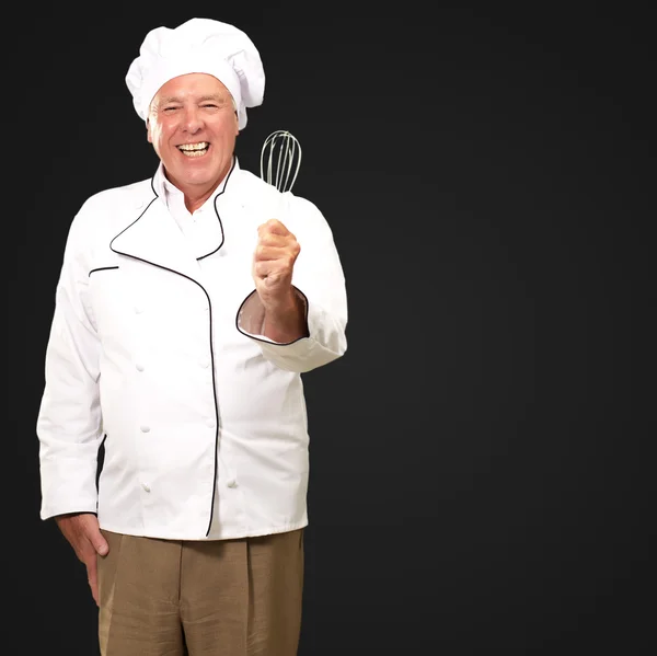 Retrato de un chef masculino mayor sosteniendo un batidor —  Fotos de Stock