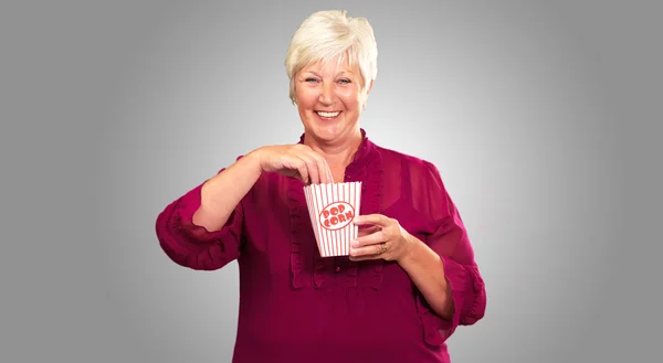 Oude vrouw eten popcorn — Stockfoto