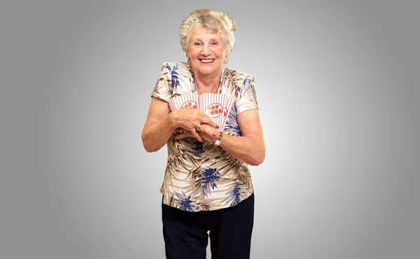 Portret van een senior vrouw met popcorn vak — Stockfoto