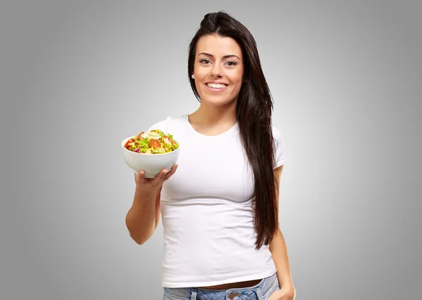 Fiatal lány mutatja egy tál saláta — Stock Fotó