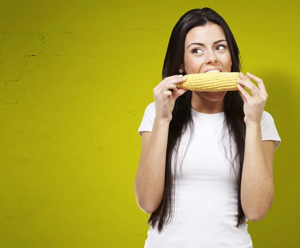 Kadın bir mısır koçanı yiyor — Stok fotoğraf