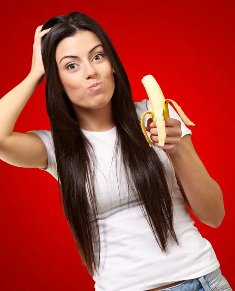 Une jeune femme mange une banane — Photo