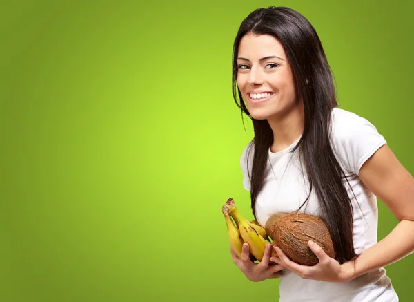 Young Girl Holding Banana And Coconut — Stockfoto