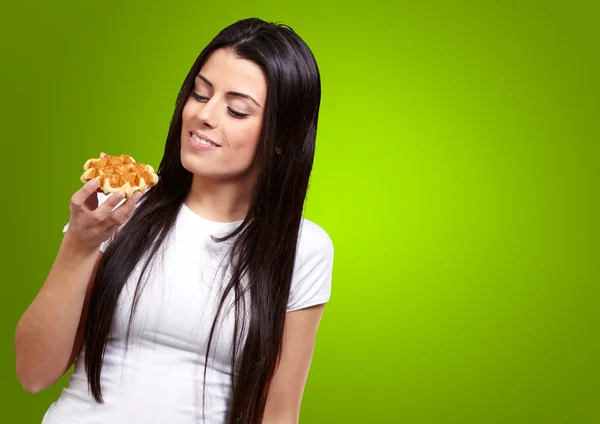 Une jeune femme tenant et regardant gaufre — Photo