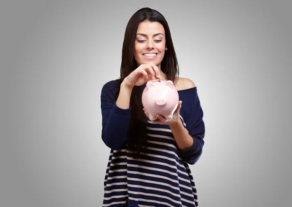 Retrato de uma jovem segurando um banco porquinho — Fotografia de Stock