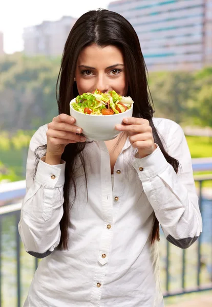 Ung flicka visar en skål med sallad — Stockfoto