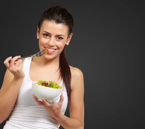 Jonge vrouw holding en eten Salade — Stockfoto