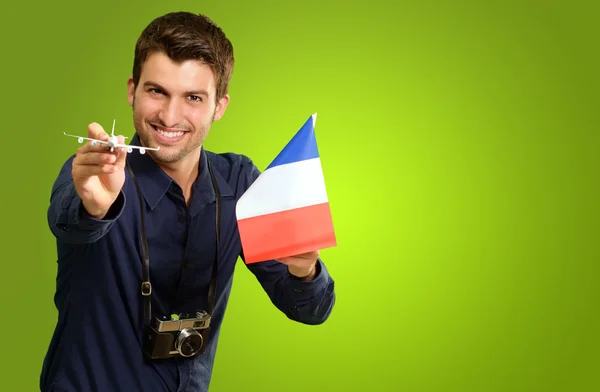 Un bărbat care deține un avion miniatural și un steag francez — Fotografie, imagine de stoc