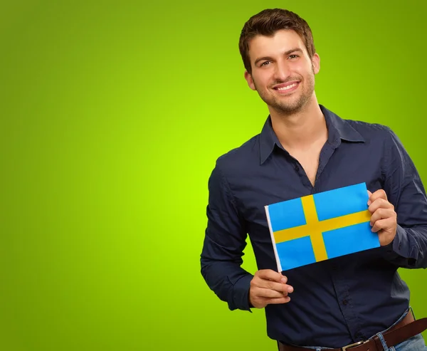 Młody człowiek trzyma flagę Szwecji — Zdjęcie stockowe