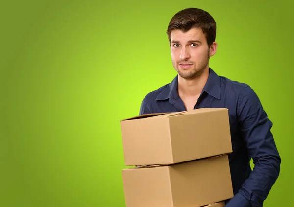 Un jeune homme tenant une pile de boîtes en carton — Photo
