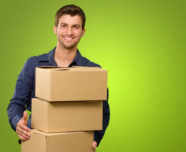 karton kutular yığını tutan genç bir adam