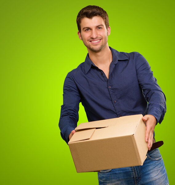 Молодой человек держит картонную коробку
