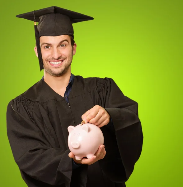 Graduate man anläggningen piggybank — Stockfoto