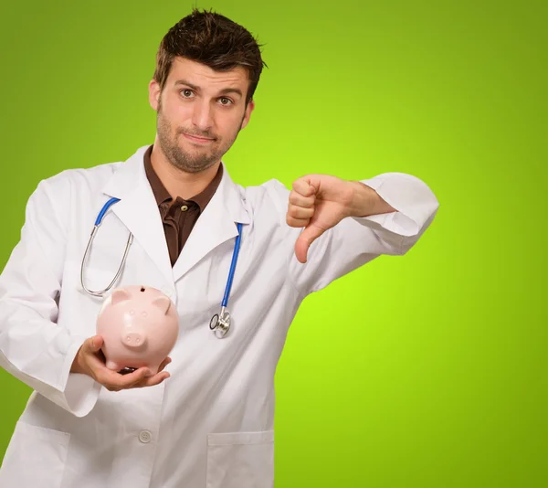 Joven doctor sosteniendo una alcancía — Foto de Stock