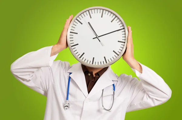 Doktor schovává tvář s hodinami — Stock fotografie