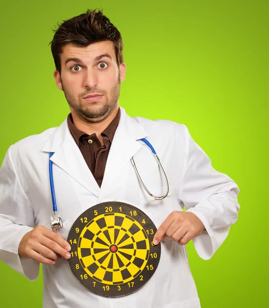 Porträtt av manliga läkare innehar en darttavla — Stockfoto
