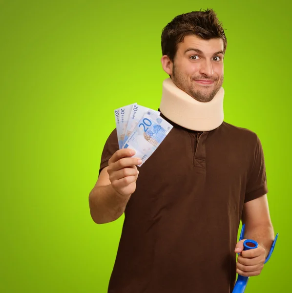 Jonge man dragen cervicale kraag houden euro biljet — Stockfoto