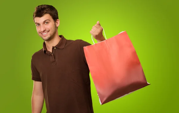 Retrato de um jovem segurando saco de compras — Fotografia de Stock