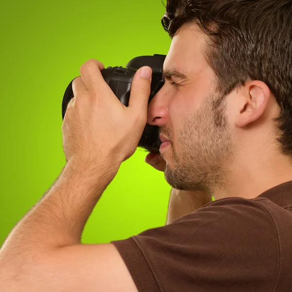 Hombre joven sosteniendo la cámara — Foto de Stock