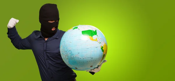 Jonge man gemaskerde bedrijf globe — Stockfoto