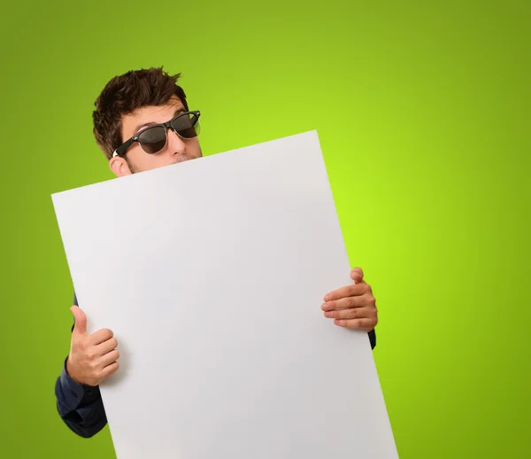 Mann mit Sonnenbrille hält Blanko-Plakat hoch — Stockfoto