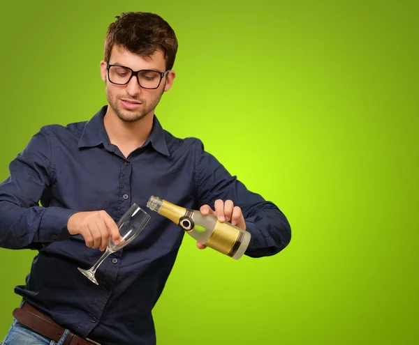 Ein junger Mann schenkt Champagner ein — Stockfoto