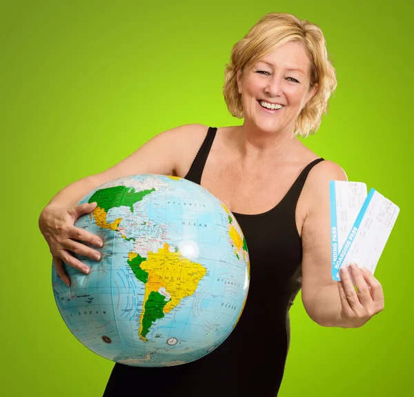 Vrouw holding globe en instapkaarten — Stockfoto