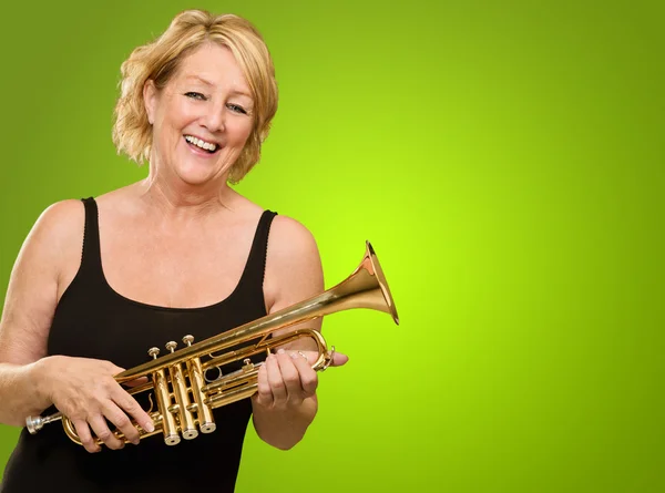 Glad mogen kvinna anläggning trumpet — Stockfoto