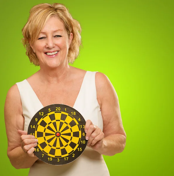 Gelukkig volwassen vrouw bedrijf dartbord — Stockfoto