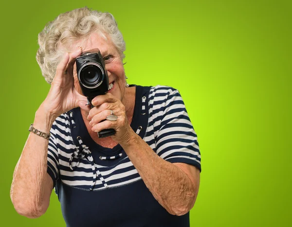 Seniorin blickt durch Videokamera — Stockfoto