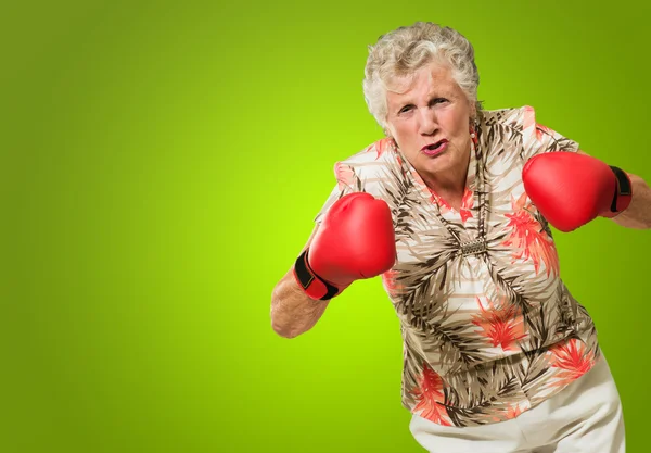 Zły starsza kobieta noszenia rękawic bokserskich — Zdjęcie stockowe